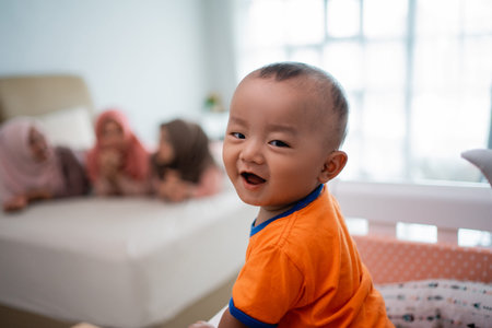 little baby boy smiling when playing with mothers friendsの写真素材