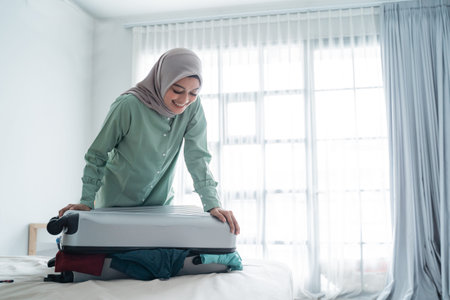 beautiful Muslim women tried to close her full suitcaseの写真素材