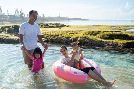 Happy family playing on the beachの写真素材