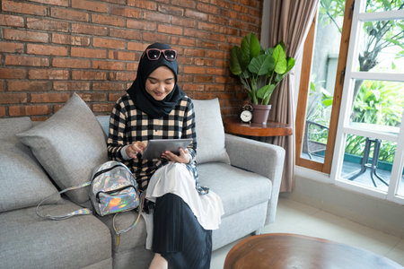 muslim woman at home using tablet
