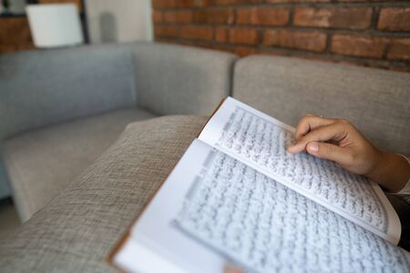 close up of quran being read by muslim. arabic text insideの写真素材