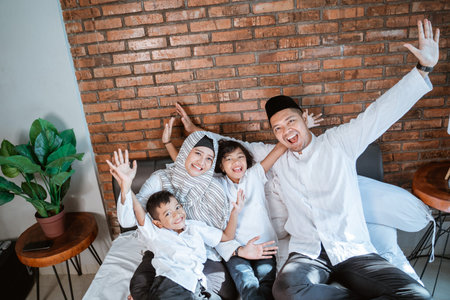 asian families with their children are relaxing and joking on the bed