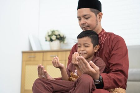 Muslim father and son praying togetherの写真素材