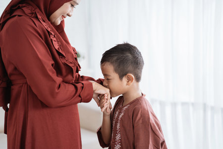 child kissing his mothers hand to apologize