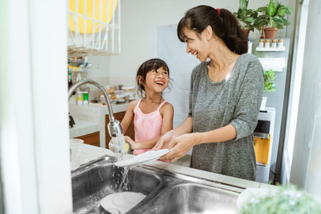 Daughter helping her mother in the kitchenの写真素材
