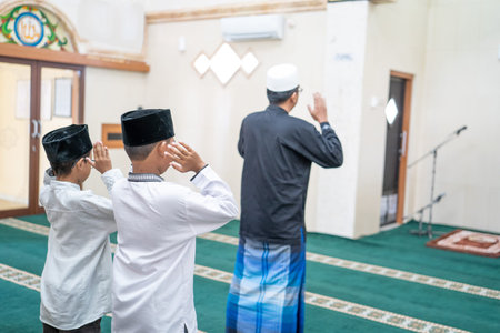 father and son praying together in the mosque