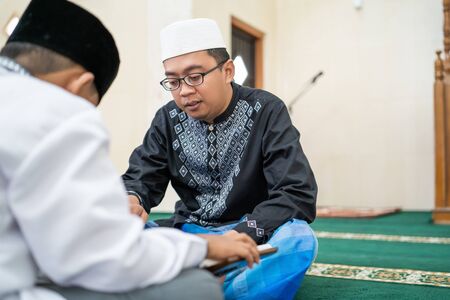 teaching muslim kid to read quranの写真素材
