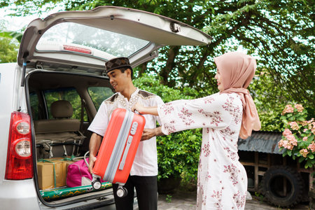 muslim couple packing suitcase in the car