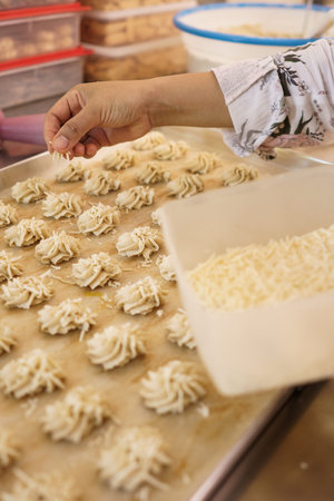 hand put a cheese topping on semprit cake