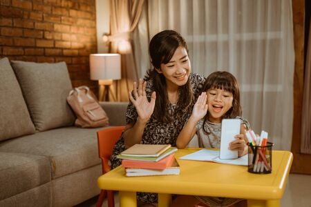 mother and daughter calling with smartphoneの素材 [FY310146879652]