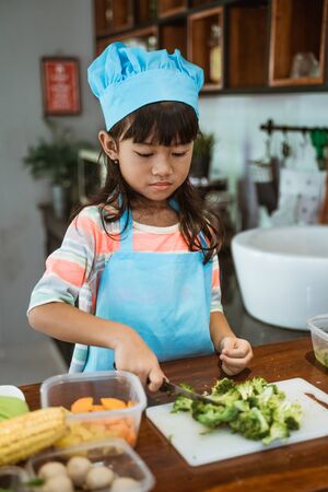 kid learning to cook at homeの写真素材