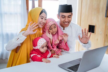 muslim family using laptop to call friendsの写真素材