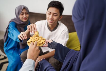 people eating eid mubarak snacksの写真素材