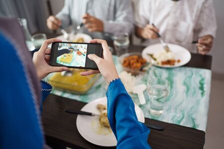 hand taking picture of indonesian traditional foodの写真素材