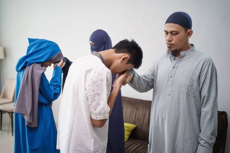 asian muslim parent shake hand in idul fitri eid mubarakの写真素材