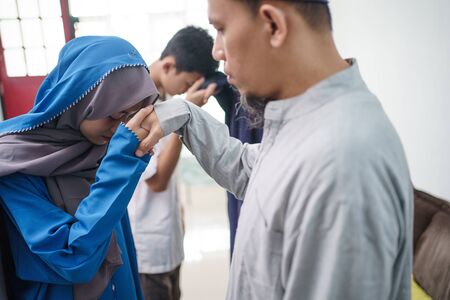 asian muslim parent shake hand in idul fitri eid mubarakの写真素材