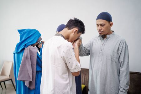 asian muslim parent shake hand in idul fitri eid mubarakの写真素材