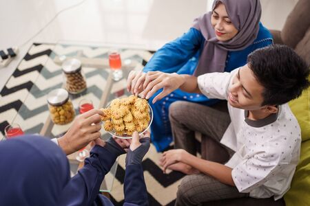 people eating eid mubarak snacksの写真素材