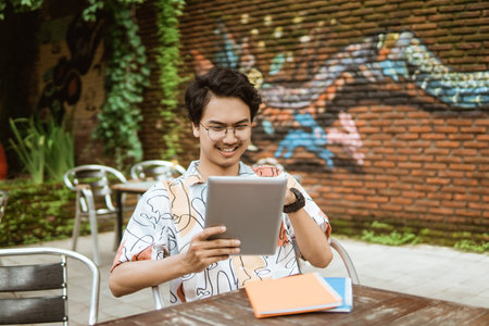 Smiling young man using tablet pc