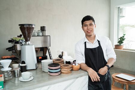 barista with lean back arm standing at workplaceの写真素材