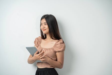beautiful girl with long hair smiling while holding a tabletの写真素材