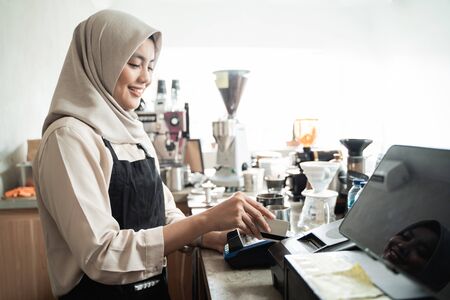 veiled cashiers swipe a credit cardの写真素材