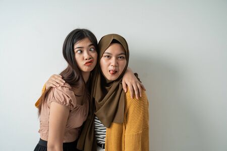 two friendly girls pose silly faces when looking at the cameraの写真素材