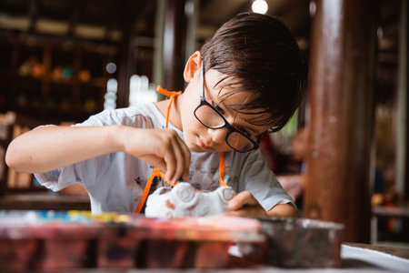 Caucasian boys paint colored crafts in pottery galleries with class friends