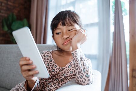 bored child play with mobile phoneの写真素材