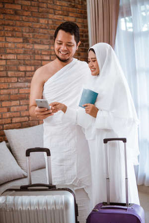 muslim couple making a phone call while umrah and hajjの写真素材