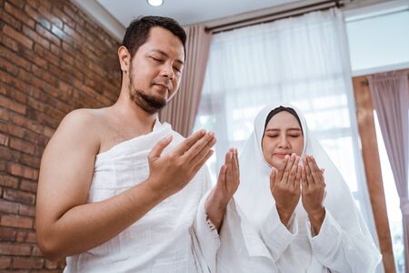 Muslim man and woman praying open armの写真素材