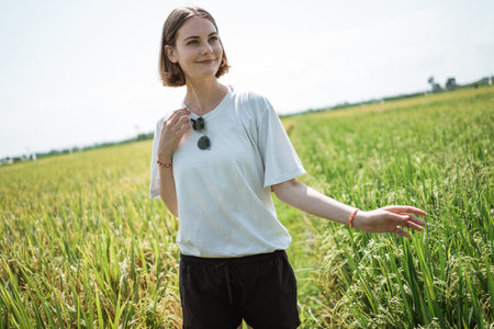 a woman poses in the middle of a rice field