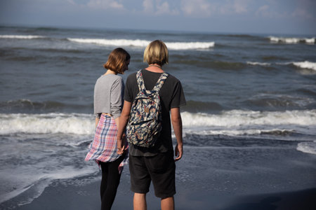 Young couple enjoy a trip together on the beach in the bright sunny day