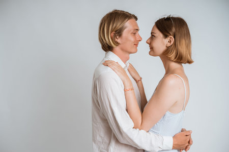 couple embracing each other over white background