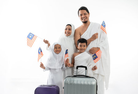 muslim umrah and haji with family holding malaysian flag