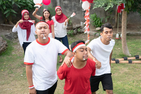 participants compete in the marble and spoon race with the audience supports