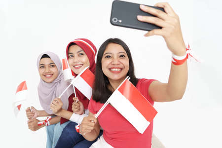 woman taking selfie while celebrating indonesian independence dayの写真素材