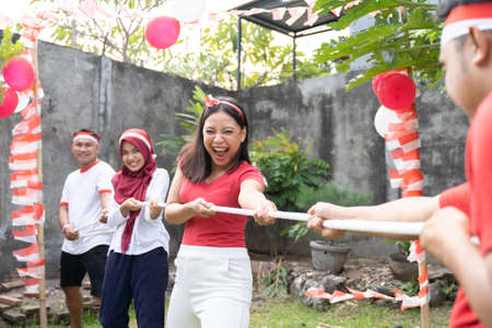 three people in one team tried to pull the rope hard during the tug-of-war competitionの写真素材
