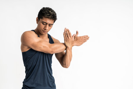 muscle man wearing sportswear stands facing side do hand stretches