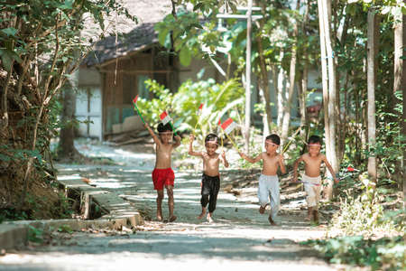 having fun group of kids running without clothes when holding small the red and white flag and raised the flagの写真素材