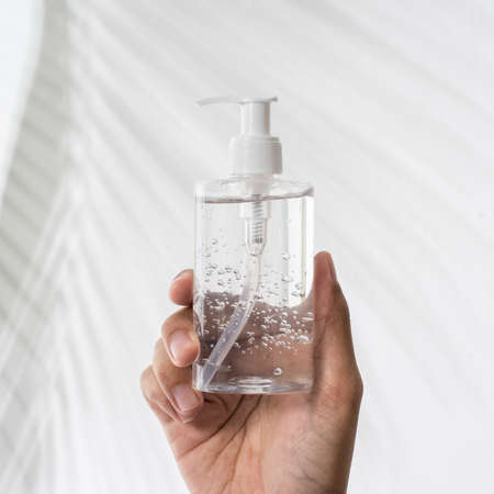 hand holding plastic bottle hand sanitizer mockupの写真素材