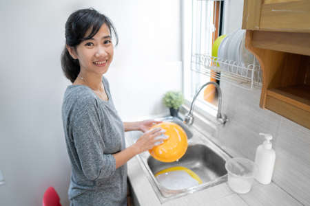 woman washing the dishes in kitchenの写真素材