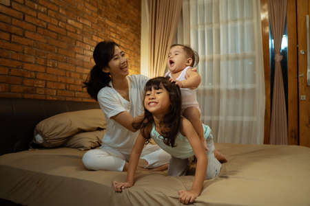 Happy kids playing riding on back of sisterの写真素材