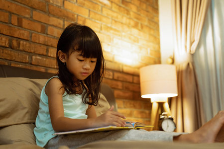 Asian little girl holding a book