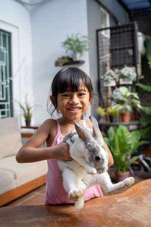 Beautiful little girl holding a funny bunnyの写真素材