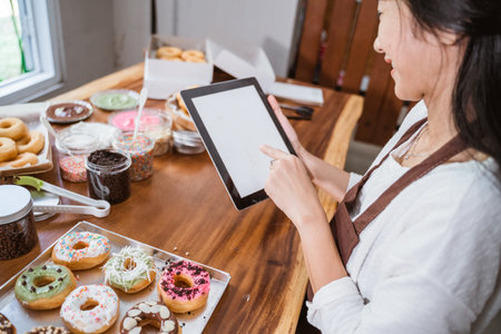 a woman wearing an apron on a tablet while sitting