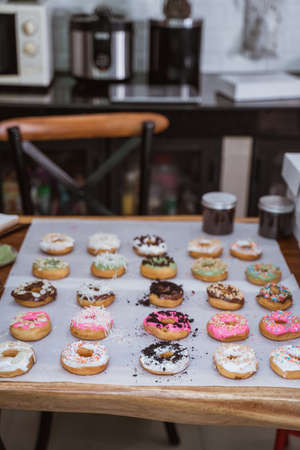 Assorted donuts with chocolate frosted, pink glazed and sprinkles donutsの写真素材
