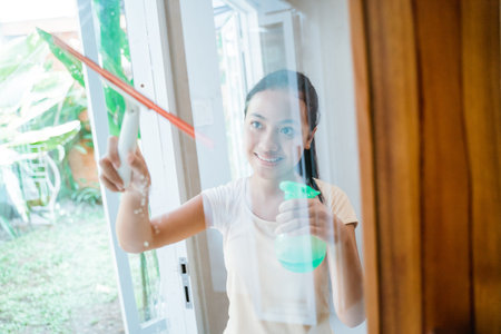 teenage girl washes a window