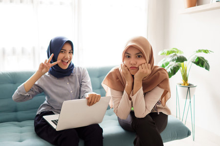 portrait of a beautiful muslim woman who is very happy to work and with her cute friend