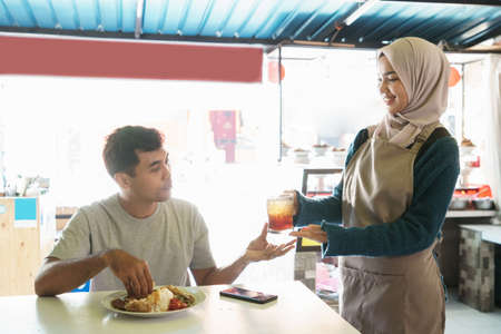 a woman gives a drink to a manの写真素材